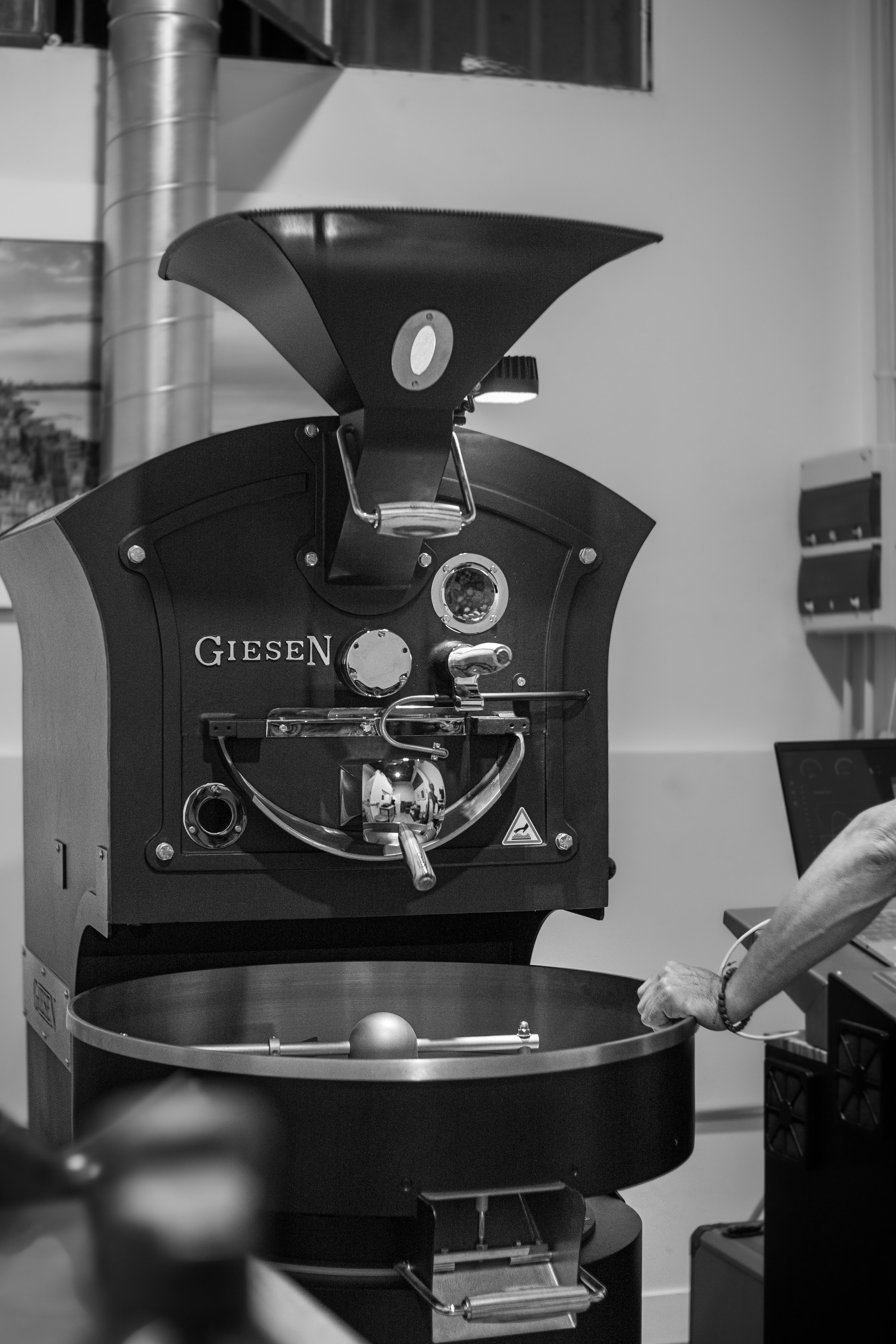 Tostador Giesen en Levante Brew & Co. durante el proceso de tueste de café en blanco y negro.