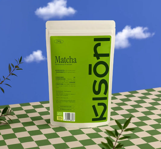 Bolsa de Matcha Ceremonial Premium Kisori de 250g sobre fondo azul con cielo y mosaico verde.